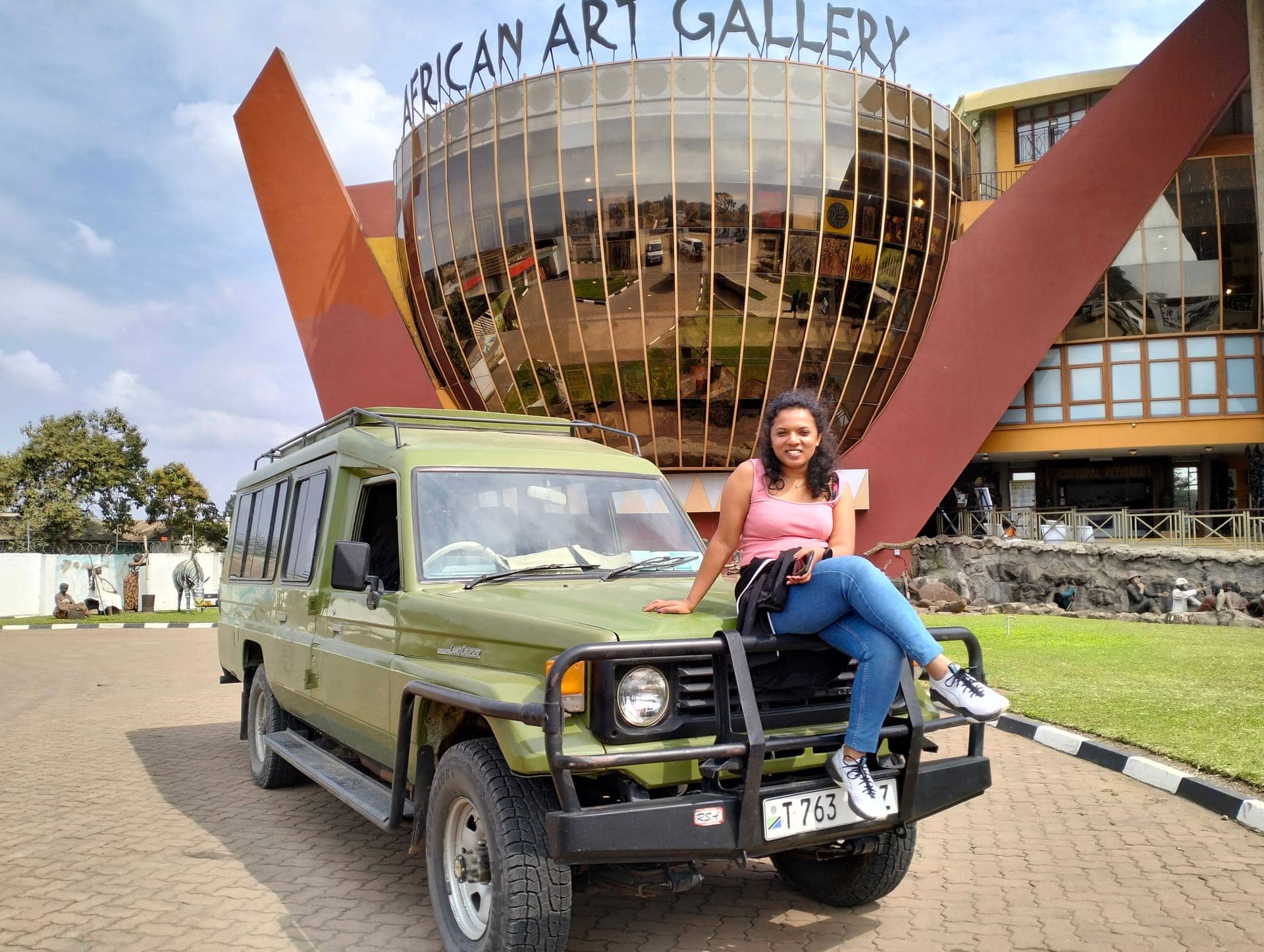 A guest with a Trust Tours vehicle at the African Art Gallery in Arusha