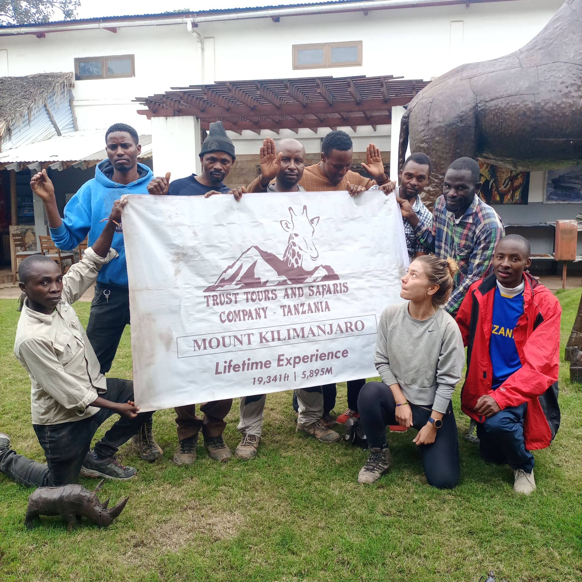 A group holding the Trust Tours Mount Kilimanjaro banner