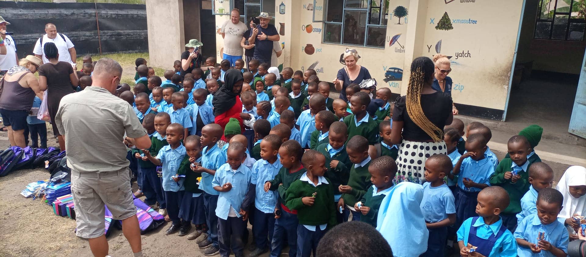 A guide handing out backpacks and supplies at a local school