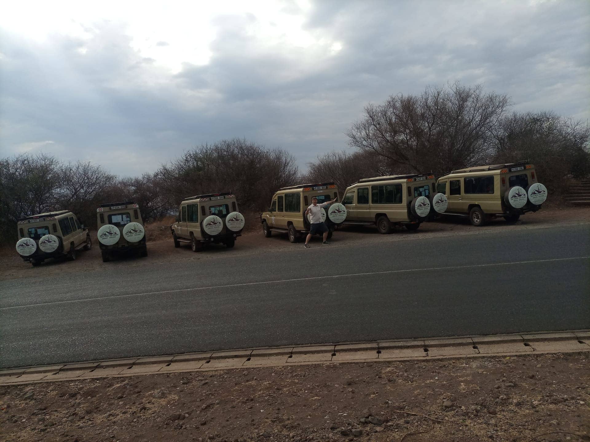 Six Trust Tours Land Cruisers lined up on the roadside