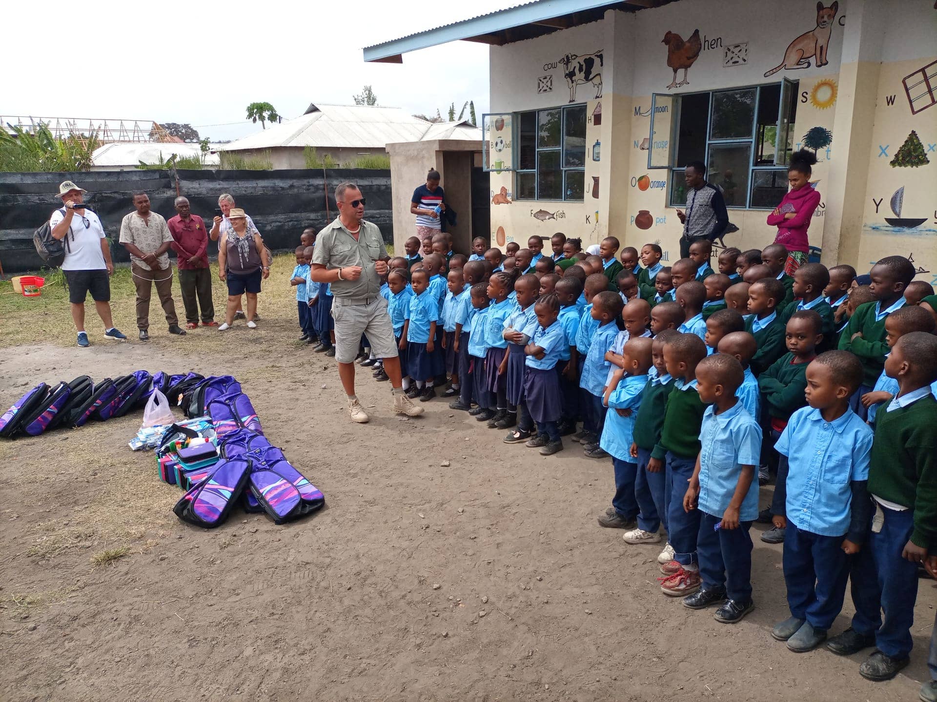 Trust Tours guests and crew handing school supplies to local children