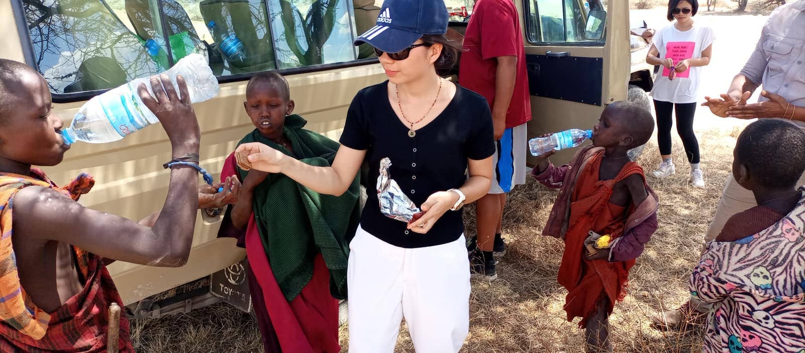 A guest sharing water with Hadzabe children on a cultural visit