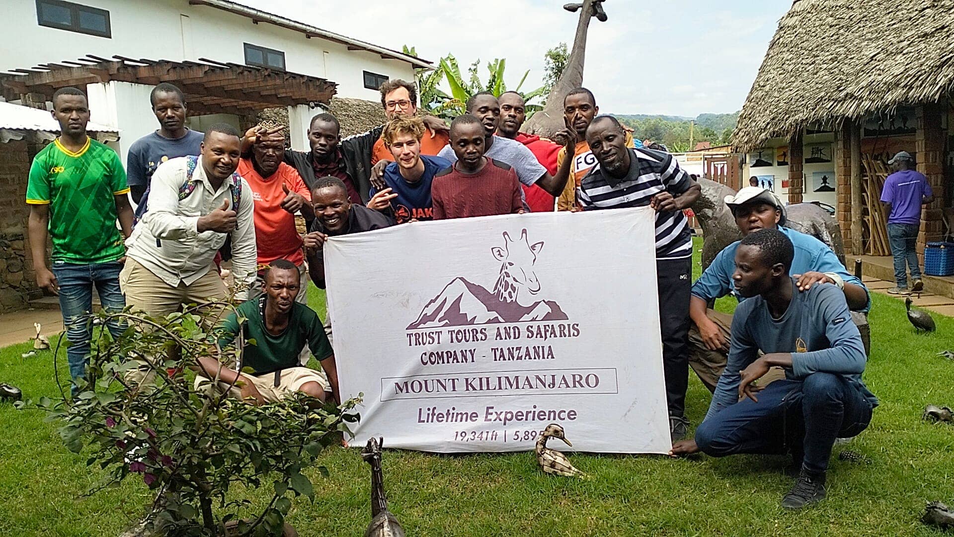 A large group holding a Kilimanjaro summit completion banner