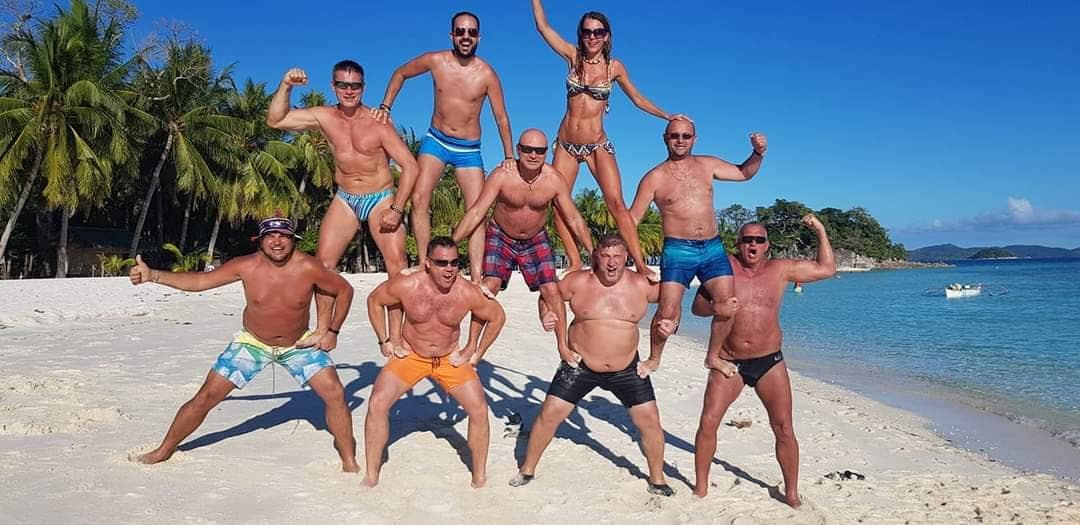 A group of guests on the white sand of a Zanzibar beach
