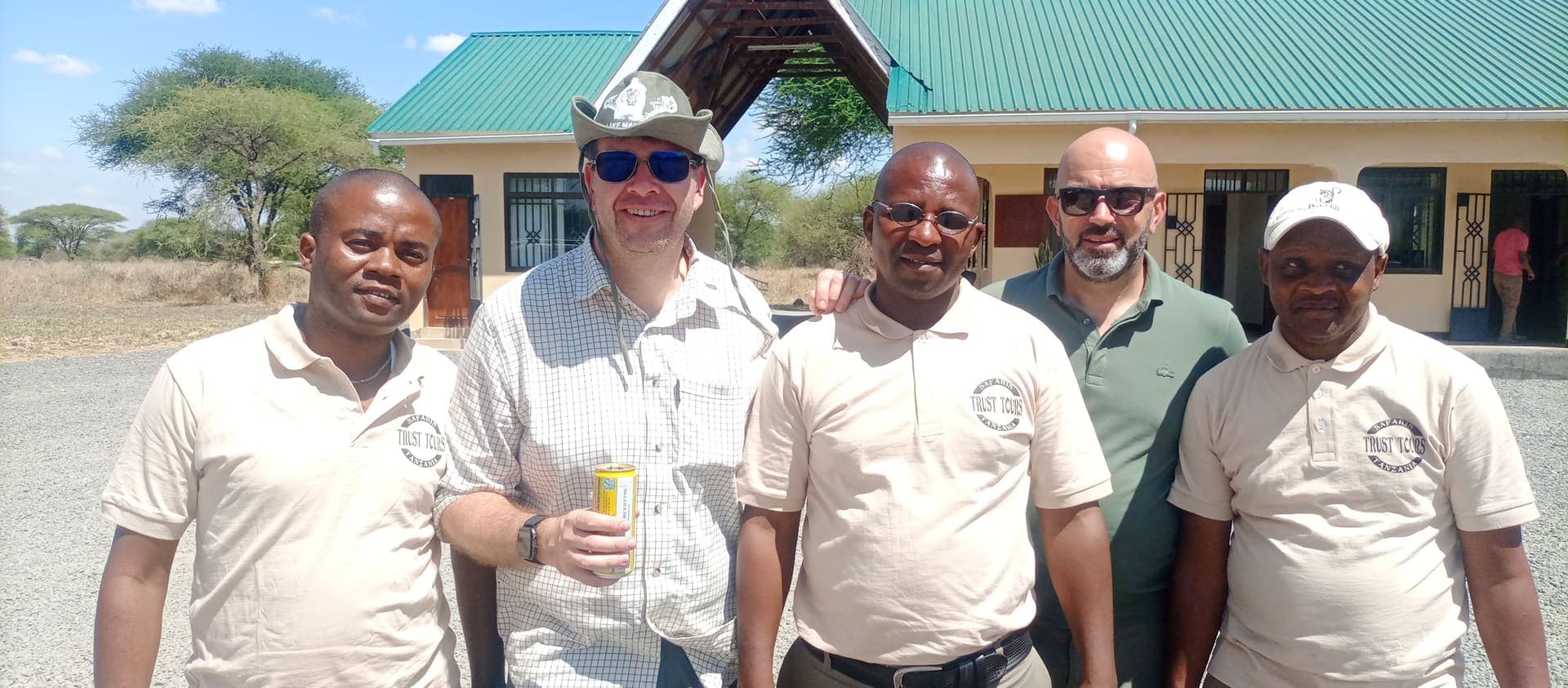 Five Trust Tours guides in branded polo shirts at a safari lodge