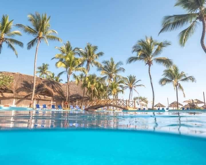 A beachfront pool fringed with palms at a Zanzibar resort